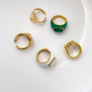 Set of five gold titanium steel rings featuring green enamel and daisy floral designs