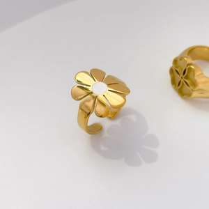 Detailed close-up of a golden daisy ring with white enamel petals and flower center