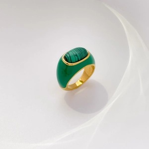 Detailed macro view of vintage gold-plated titanium ring with green enamel and malachite inlay