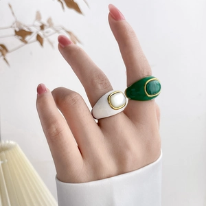 Detail of luxury colorful enamel and turquoise rings worn on fingers with golden accents