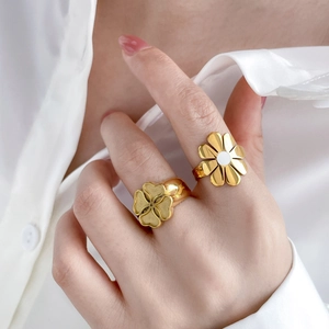 Detail of flower shaped titanium steel rings with enamel inlay and turquoise accents