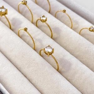 Macro shot of 18K gold plated twisted band rings with four-prong set cubic zirconia