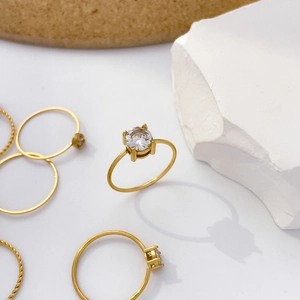 Detailed shot of 18K gold plated twisted rings and four-prong solitaire zircon ring