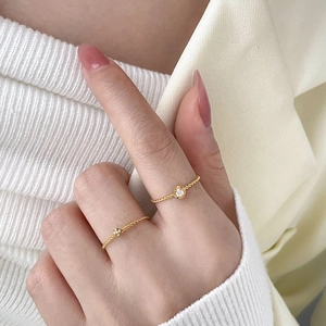 Minimalist 18K gold plated titanium twist ring with four-prong cubic zirconia setting