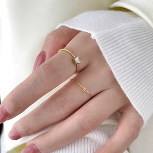 Close-up of thin 18K gold plated titanium twist ring with four-prong zircon setting