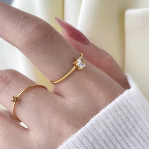 Close-up of 18K gold plated twisted ring set with four-prong round zircon inlay