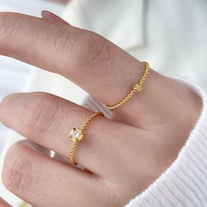 Macro view of 18K gold plated twisted band rings with round zircon inlay on hand