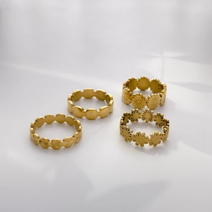 Détail de quatre bagues marguerites dorées avec finition mate et plaqué or 18 carats