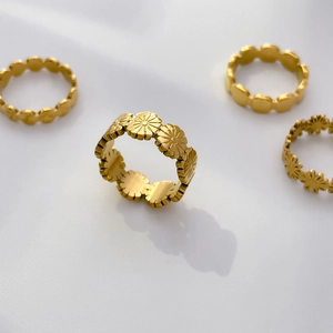 Détail de bagues en titane plaqué or 18K avec motifs marguerites mates et ovales gaufrés
