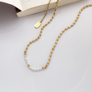 Close-up of 18K gold plated necklace with delicate freshwater pearls and metal bean beads