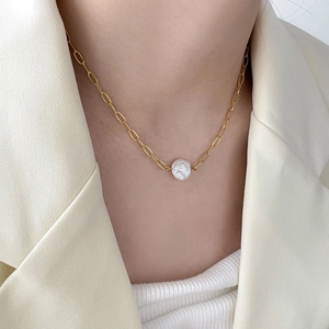 Close-up of minimalist 18K gold plated necklace with freshwater pearl and oval pendant