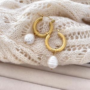 Close-up of C-shaped 18K gold-plated titanium earrings with three dangling pearls