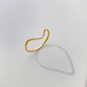 Detailaufnahme des V-förmigen Goldrings mit Zirkonia-Steinen und gewelltem Banddesign
