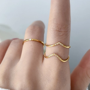 Makroaufnahme von 18 Karat Gold Chevron- und Solitärringen am Finger