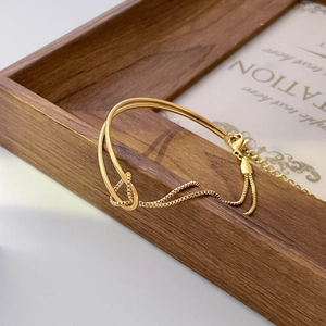Detail shot of a minimalist gold bracelet with integrated curb chain and lobster clasp