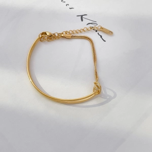 Detailed shot of 18K gold plated bangle with integrated chain link and lobster clasp