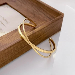 Detailed close-up of a crossover golden titanium steel bracelet with polished finish