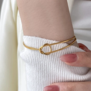 Detail of 18K gold-plated crater wide bracelet featuring a linked snake chain design