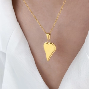Détail du collier en acier doré 18K avec pendentif cœur fondu porté par un modèle