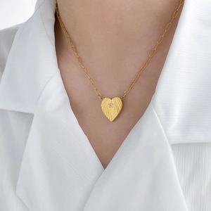 Détail du collier cœur plaqué or 18K avec texture soleil et pendentif étoile en zircon