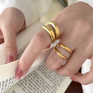 Elegant 18K gold plated double layer intertwined rings worn by model over a book