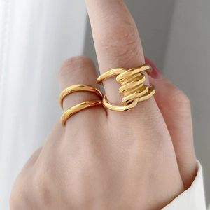 Detail of twisted and double-layer 18K gold-plated titanium steel rings worn on finger