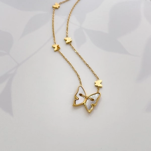 Détail du collier papillon plaqué or 18K avec nacre incrustée et mini breloques élégantes