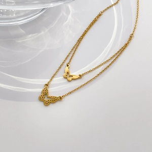 Gros plan détaillé d'un collier double couche en or avec des motifs papillons ciselés