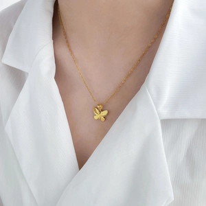 Élégant collier papillon double couche plaqué or 18 carats sur une chemise blanche