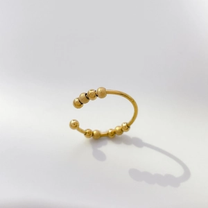 Detail of adjustable gold spinner ring featuring alternating smooth and frosted beads