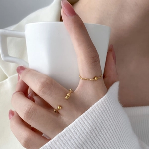 Detailed view of 18K gold plated stackable rings with beads and twisted band texture