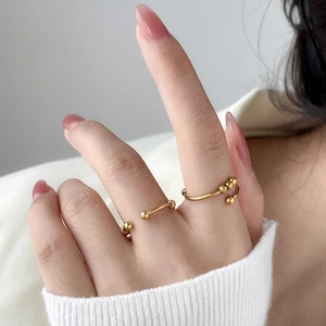 Detail of 18K gold plated titanium steel wavy rings with movable beads on model