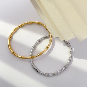 Detailed close-up of bamboo-style curved cuff bracelets in gold and silver finish