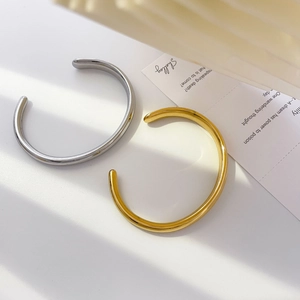 Minimalist C-shaped open bangle bracelets in gold and silver with elegant light and shadows