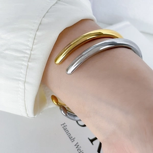 Close-up of gold and silver chunky hollow bangles on wrist with minimalist style