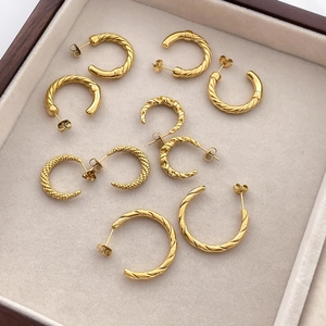 18K gold plated C-shape twisted rope earrings in various textures displayed on jewelry tray