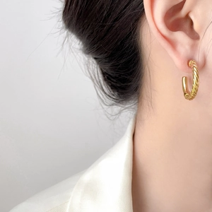Elegant twisted rope and smooth surface C-shape gold earrings shown on a model