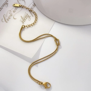 Detail of gold double-layered snake chain with knot design and K18 hallmark tag