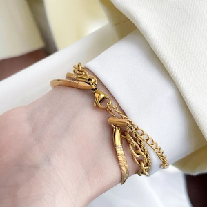 Detailed view of triple-layered gold snake chain and cable chain with lobster clasp