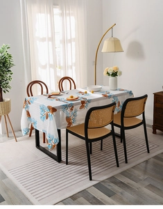Detail of white cotton linen tablecloth with pine cone pattern in a Nordic dining room