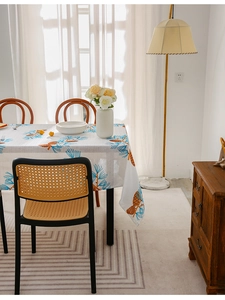 Close-up of oil-proof tablecloth with orange pine cones and blue pine needles pattern