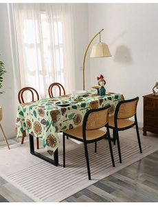 Detailed close-up of a green sunflower tablecloth in a sunlit Nordic dining room