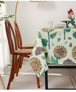 Close-up of sunflower print tablecloth with rustic cotton linen texture in pale green