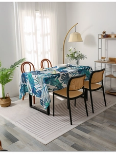 Detail of Nordic monstera leaf tablecloth in a modern sunlit dining room setting