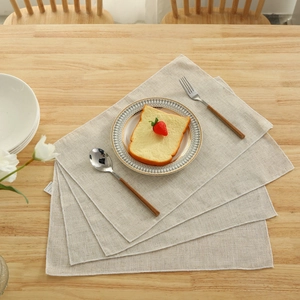 Set of 4 minimalist linen placemats on wooden table with elegant cutlery and dinnerware