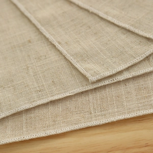 Solid color natural linen napkin with white overcast stitched edges for table setting