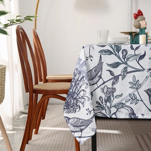Nordic style cream tablecloth with navy blue floral and bird patterns in a home dining setting