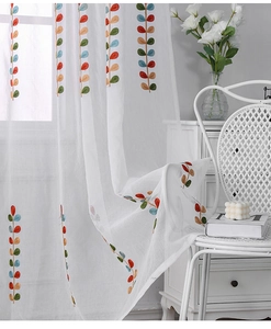 Close-up of colorful leaf embroidery on semi-transparent white sheer curtains for windows