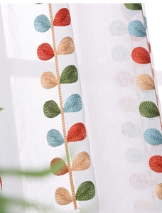 Detail of colorful leaf embroidery on semi-transparent white sheer curtains for windows