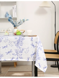 Detail of dragonfly and floral embroidery on beige linen-textured dining tablecloth